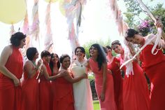 a group of women in red dresses standing next to each other with balloons and streamers