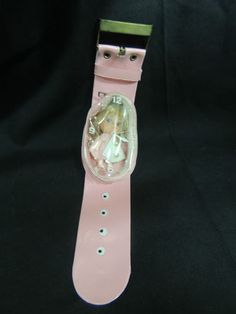 a pink watch strap with an image of a woman in a glass case on it