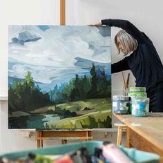 a woman is painting in an art studio