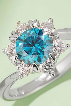 a blue and white diamond ring on a green background