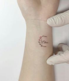 a woman's arm with a small tattoo on it