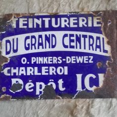 an old blue and white sign that is on the wall