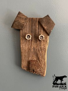 a wooden mask hanging on the wall with two eyes and one nose made out of wood