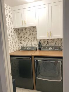 an empty laundry room with two washers and dryer