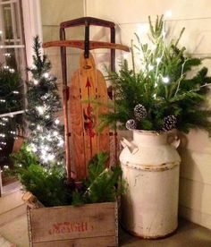 a wooden sleigh with christmas trees in it next to a potted plant