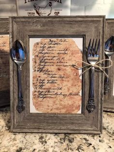 an old fashioned frame with spoons and forks in it on top of a counter