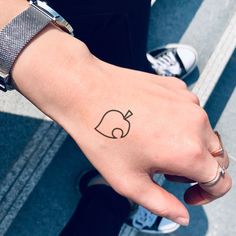 a person's hand with a small tattoo on the left side of their wrist