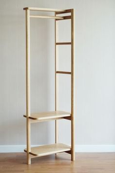 a wooden shelf sitting on top of a hard wood floor next to a white wall