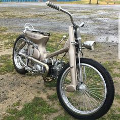 a silver motorcycle parked on top of a grass covered field