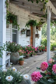 a porch with potted plants and flowers on it