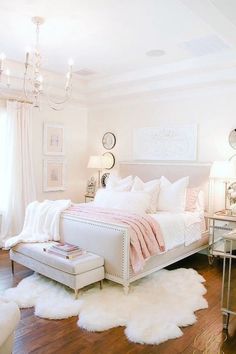 a bedroom with white fur rugs and chandelier