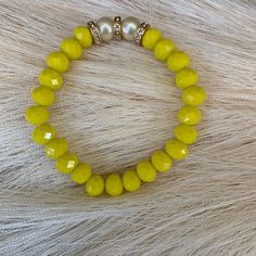 Introducing our stunning Yellow Faceted Rondelle Glass Bracelet, a must-have addition to any jewelry collection. This beautifully crafted piece features a series of yellow glass beads that have been expertly cut into a Rondelle shape, creating a faceted surface that catches the light with every movement. The bright and sunny yellow color of the beads adds a cheerful touch to any outfit, making it perfect for wearing during the summer months. In addition to the yellow glass beads, the bracelet also includes two white pearls, which add a touch of elegance and sophistication to the overall design.  Crafted with care and attention to detail, this Yellow Faceted Rondelle Glass Bracelet with 2 white pearls is sure to become a favorite piece in your jewelry collection. It is versatile enough to b Yellow Beaded Stretch Bracelet As Gift, Yellow Stretch Bracelet As A Gift, Elegant Yellow Beaded Bracelets For Jewelry Making, Elegant Yellow Adjustable Beaded Bracelets, Elegant Yellow Beads Gift, Elegant Stretch Bracelet With Colorful Beads, Elegant Yellow Jewelry With Colorful Beads, Yellow Beaded Bracelet Jewelry, Adjustable Yellow Beaded Bracelets With Faceted Beads