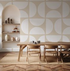 a dining room table and chairs in front of a wall with circles painted on it