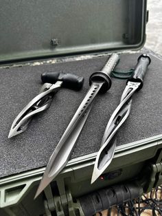 three knives are laying on top of a tool box