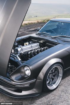 an old car with its hood open on the road