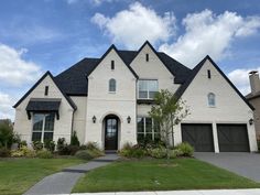 a large white brick house with two garages