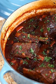 a blue pot filled with meat and vegetables