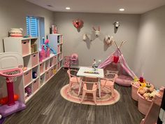 a child's playroom with pink furniture and accessories