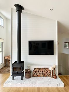 Our newly installed Nectre 15 Fireplace. We built a hearth out of old bricks from the Cooroy Brickworks purchased off Marketplace. Laid the bricks on cement sheet as we have timber floors and then primed / painted the bricks mat white - Dulux Whisper White. Moved our electrical and mounted the TV on the wall beside the fireplace. Placed a vintage white stool under the TV with stacked wood and a vintage copper bucket for kindling. Woodstove Ideas, Wood Heaters, Small Wood Burning Stove, Standing Fireplace, Tv Fal, Wood Burning Stoves