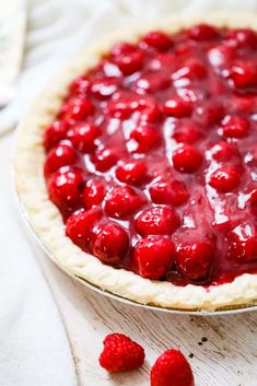 a close up of a pie with raspberries on it