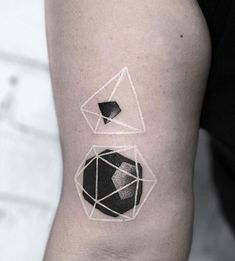 a black and white geometric tattoo on the left arm, with an image of a diamond