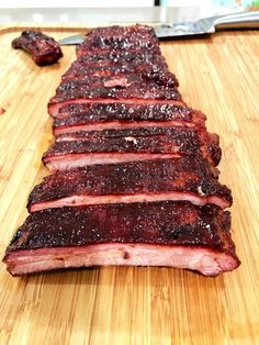 sliced meat sitting on top of a wooden cutting board