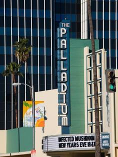 the palace theater in las vegas, nv with palm trees and tall buildings behind it