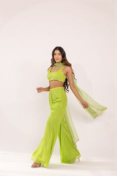 Featuring a neon green glass neck blouse in georgette base. It is paired with a solid crepe matching flared sharara pants having embroidered waist band and net dupatta with lace edging. Color: GREEN FABRIC: GORGETTE Delivery time 15 to 20 days Green Fitted Designer Pant Set, Fitted Pista Green Georgette Palazzo Set, Fitted Green Georgette Palazzo Set, Green Georgette Palazzo Set For Navratri, Floor-length Pista Green Georgette Palazzo Set, Pista Green Georgette Palazzo Set For Navratri, Fitted Green Palazzo Set For Designer Wear, Green Designer Pant Set For Diwali, Pista Green Georgette Sharara For Navratri