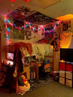 a dorm room with lights strung from the ceiling and pictures on the wall above it