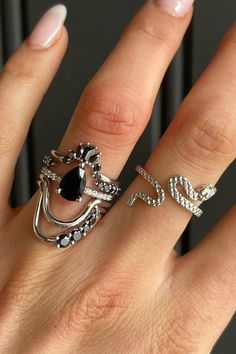 a woman's hand with two rings on it and one has a black stone in the middle