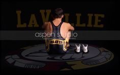 a man sitting on top of a wrestling mat in front of a wall with the words lavelie