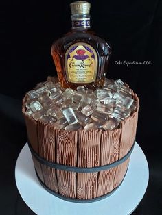 a cake made to look like a barrel with ice cubes and a bottle on top