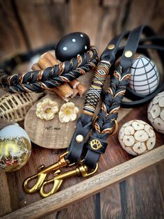 an assortment of decorative items displayed on a wooden tray with gold scissors and other accessories