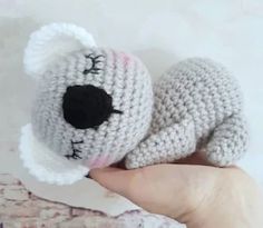 a hand holding a small crocheted stuffed animal