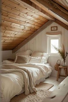 an attic bedroom with white bedding and wooden walls