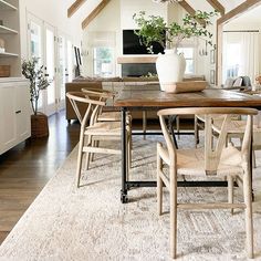 a dining room table with chairs and a potted plant on top of the table