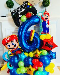 a birthday cake made to look like mario and luigi's 6th birthday with balloons