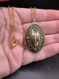 In good vintage condition!  Wear on finish.   Great details! Antique Gold Metal Locket Necklace, Vintage Oval Jewelry With Adjustable Chain, Antique Cross Pendant Necklace For Formal Occasions, Antique Brass Cross Pendant Necklace, Vintage Round Metal Locket Necklace, Vintage Oval Pendant Necklace With Antique Finish, Antique Gold Cross Pendant Necklace, Retro Gold Jewelry With Antique Finish, Ornate Gold Cross Pendant Necklace