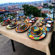 there are many plates and bowls on the table with city view in the back ground