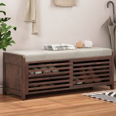 a wooden bench sitting on top of a hard wood floor next to a potted plant