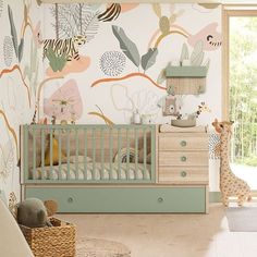 a baby's room decorated in pastel colors with an animal wallpaper and giraffe toy