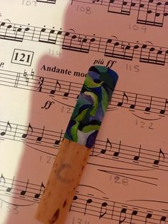 a piece of music paper with a wooden stick sticking out of it's center