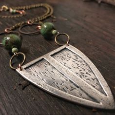 This Sterling Silver, Shield Pendant Measures Approx. 4.5 X 5.5 Cm And Comes On An 8" Antiqued, Brass Chain With A 3" Extender. Green Ceramic & Natural Stone Beads With Subtle, Copper Details. There's A Light Patina To Make The Hand-Texturing Really Pop! 100% Handmade By Me And One Of A Kind! .925 Unique Etched Sterling Silver Necklace, Silver Etched Sterling Silver Necklace, Etched Sterling Silver Necklaces, Antique Silver Etched Sterling Silver Necklace, Artisan Silver Etched Necklace, Unique Silver Etched Necklaces, Artisan Metal Jewelry With Etched Details, Unique Etched Metal Jewelry, Artisan Etched Metal Jewelry