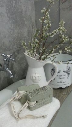 a bathroom sink with two soap bars and a vase filled with flowers on top of it