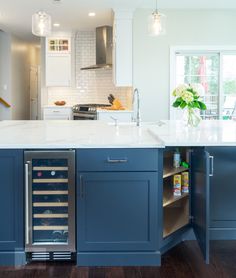 an open wine cooler in the middle of a kitchen