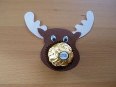 a chocolate cupcake with a reindeer's head on it and a gold medal in the middle