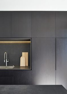 a kitchen with black cabinets and a white sink