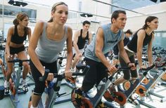 a group of people riding stationary bikes in a gym