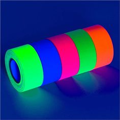 a roll of neon colored tape sitting on top of a blue table next to a light