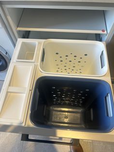 a white and blue dishwasher sitting on top of a counter next to a dryer